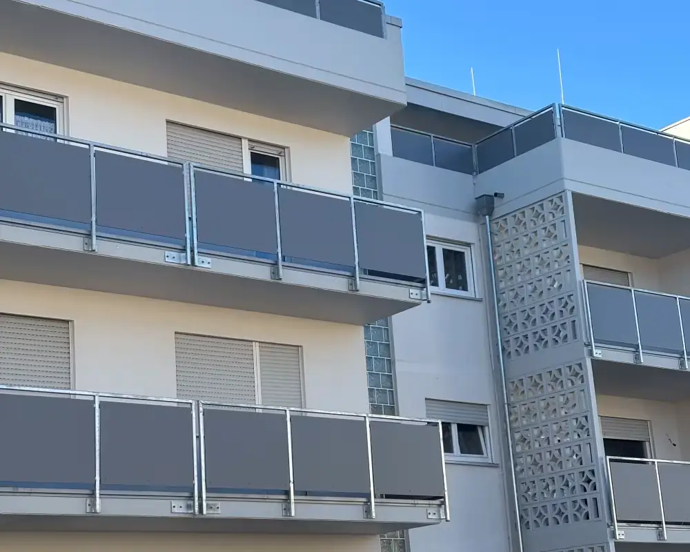 Mehrfamilienhaus in Leimen nach der Sanierung: helle Fassade, neue graue Balkongeländer