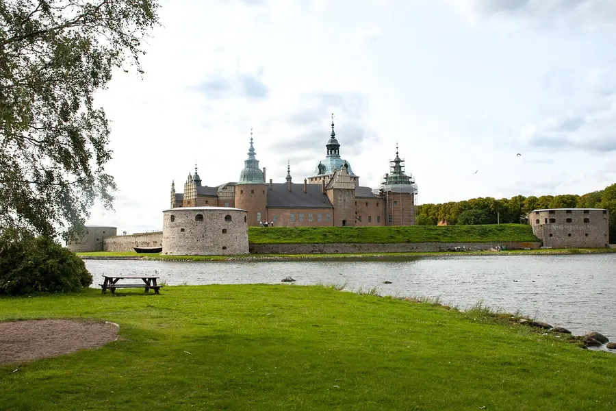 Kalmar slott omgivet av gröna gräsmattor och vatten.
