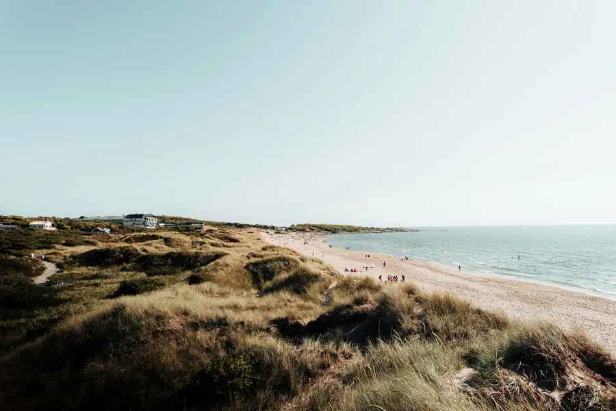 Strandnära röd fiskestuga i Halmstad med havet i bakgrunden.