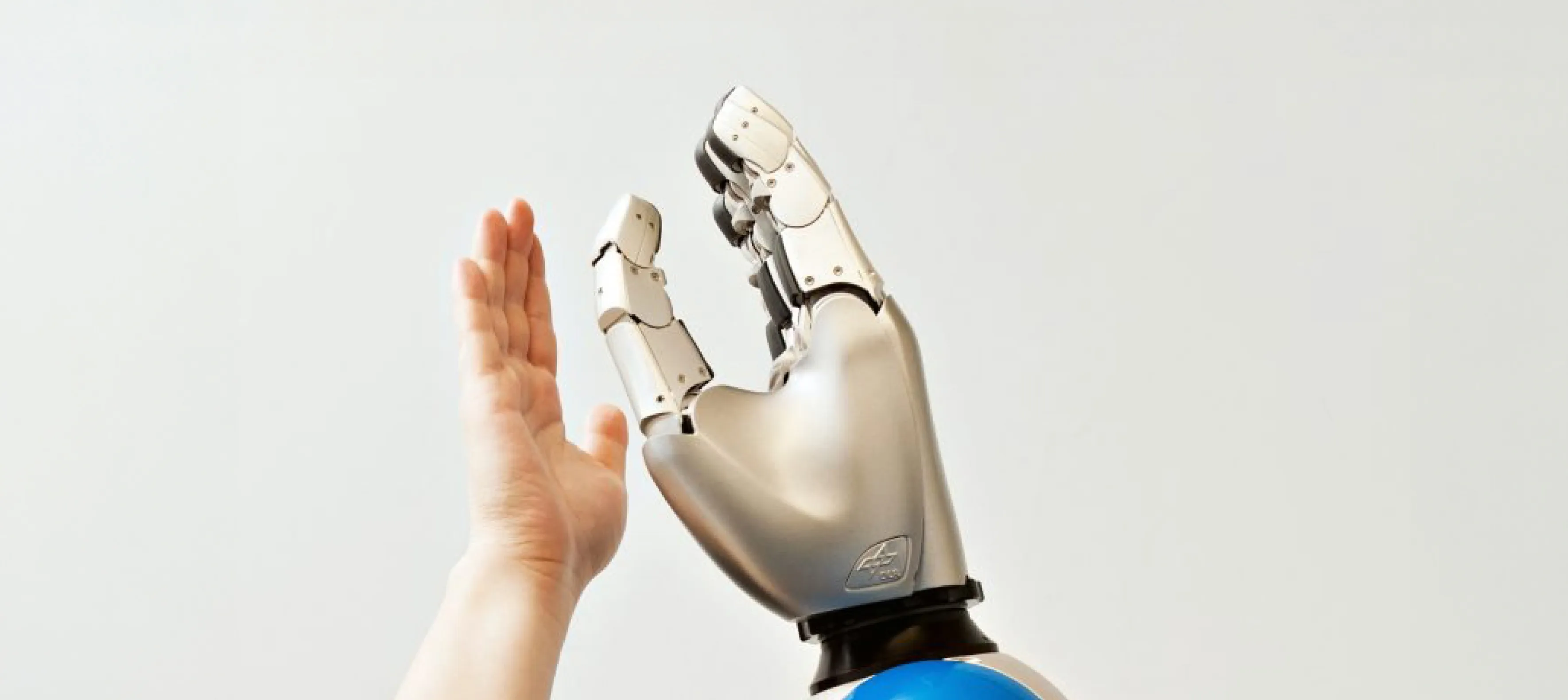 a hand reaching up towards a robot's hand