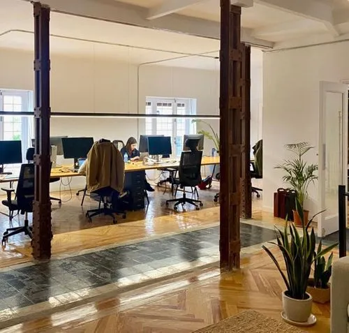 A modern office with wooden floors and iron columns