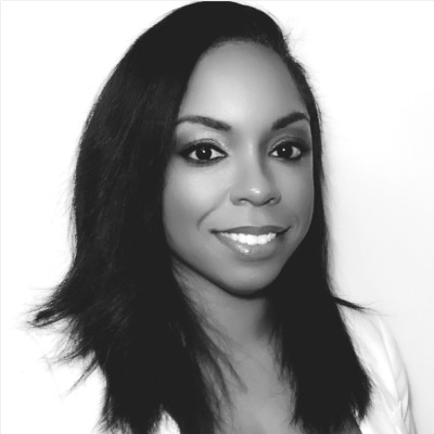 Black and white portrait of a smiling woman with long hair wearing a white top.