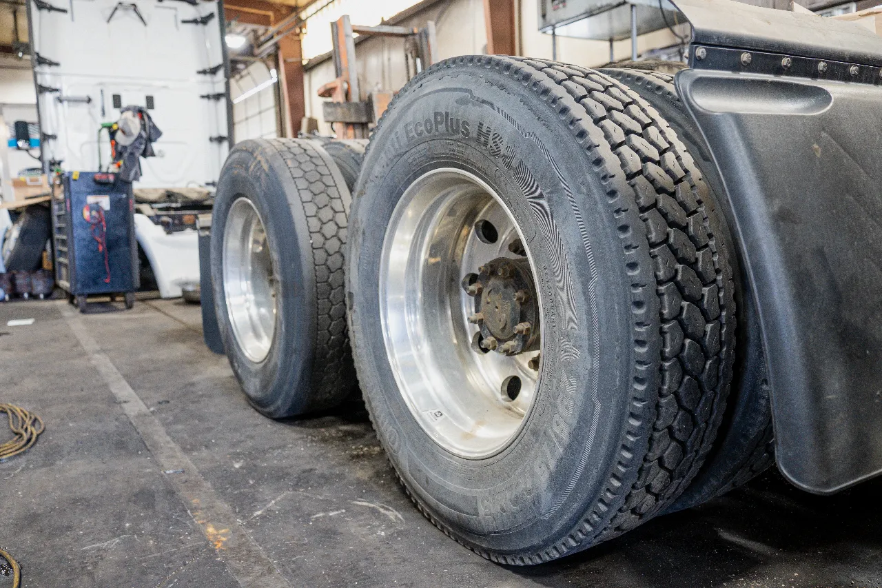 Two heavy-duty tires sat in a repair shop bay.