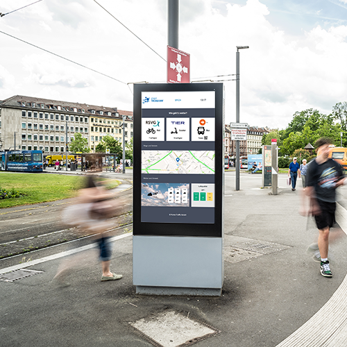 Bahnhof Draußen in Troisdorf mit City Dashboard Stele, drumherum laufen Menschen