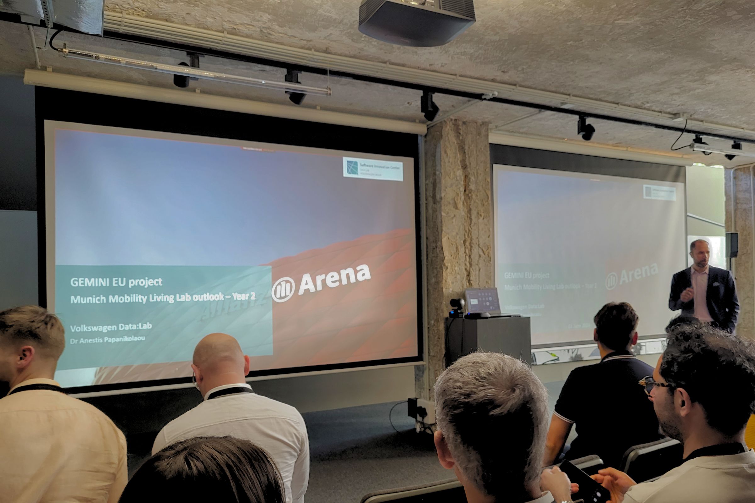 Gemini Projekt Meeting in der Allianz Arena München, zu sehen ein Vortraghaltender vor der Titelseite der Projektpräsentation