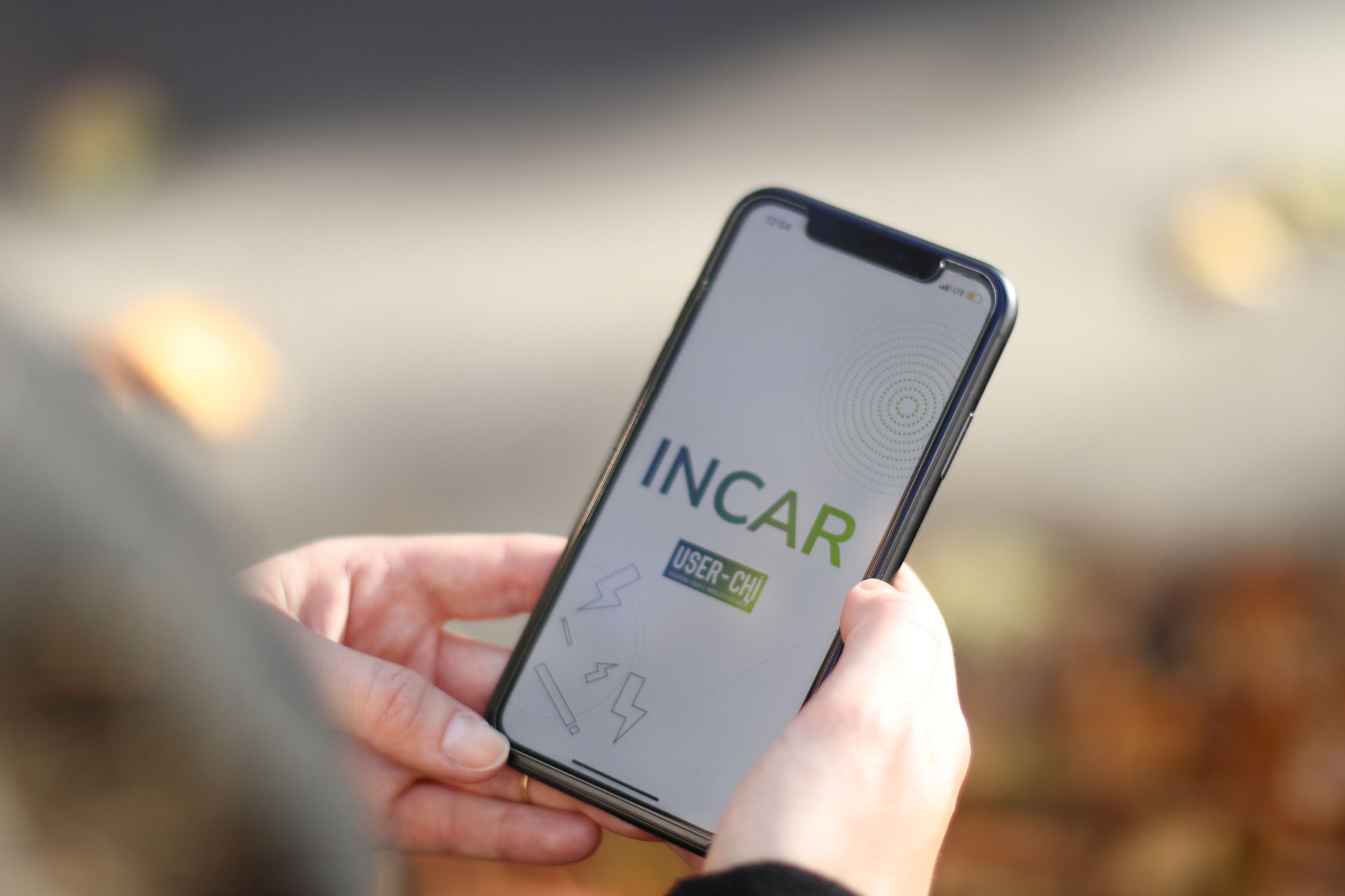 Hand hält Handy mit INCAR App zu sehen ist der Startscreen