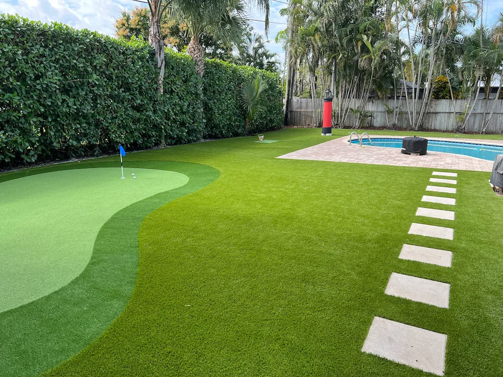 a backyard with artificial grass and a pool