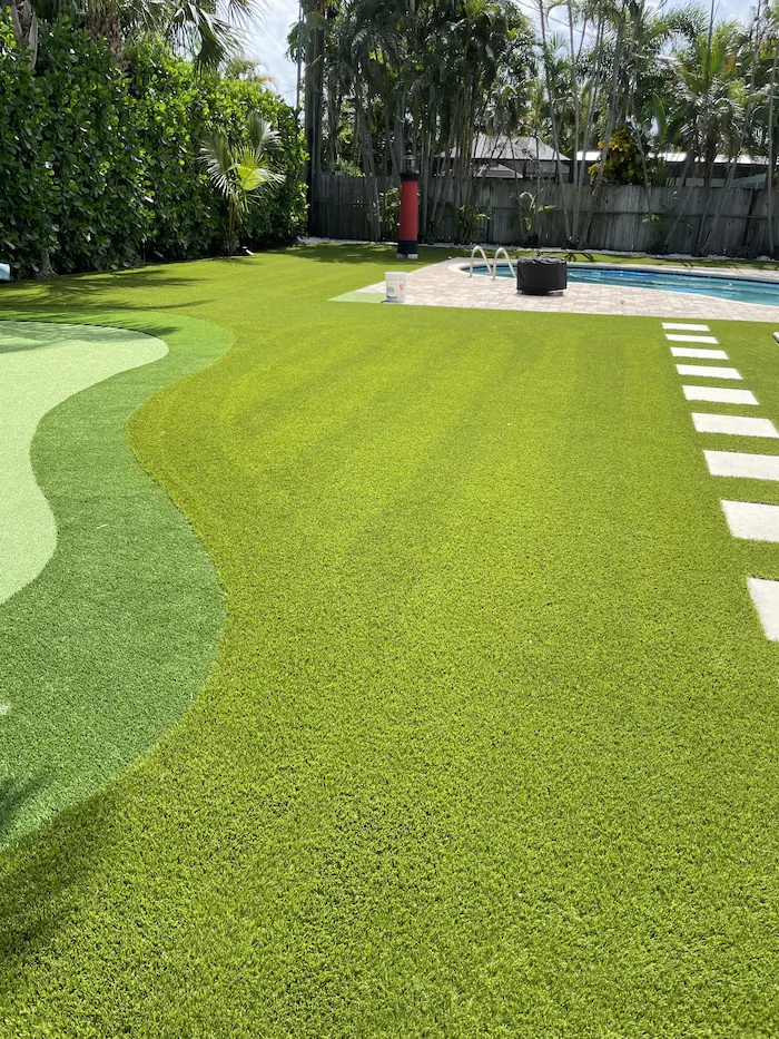 a backyard with green grass and a pool