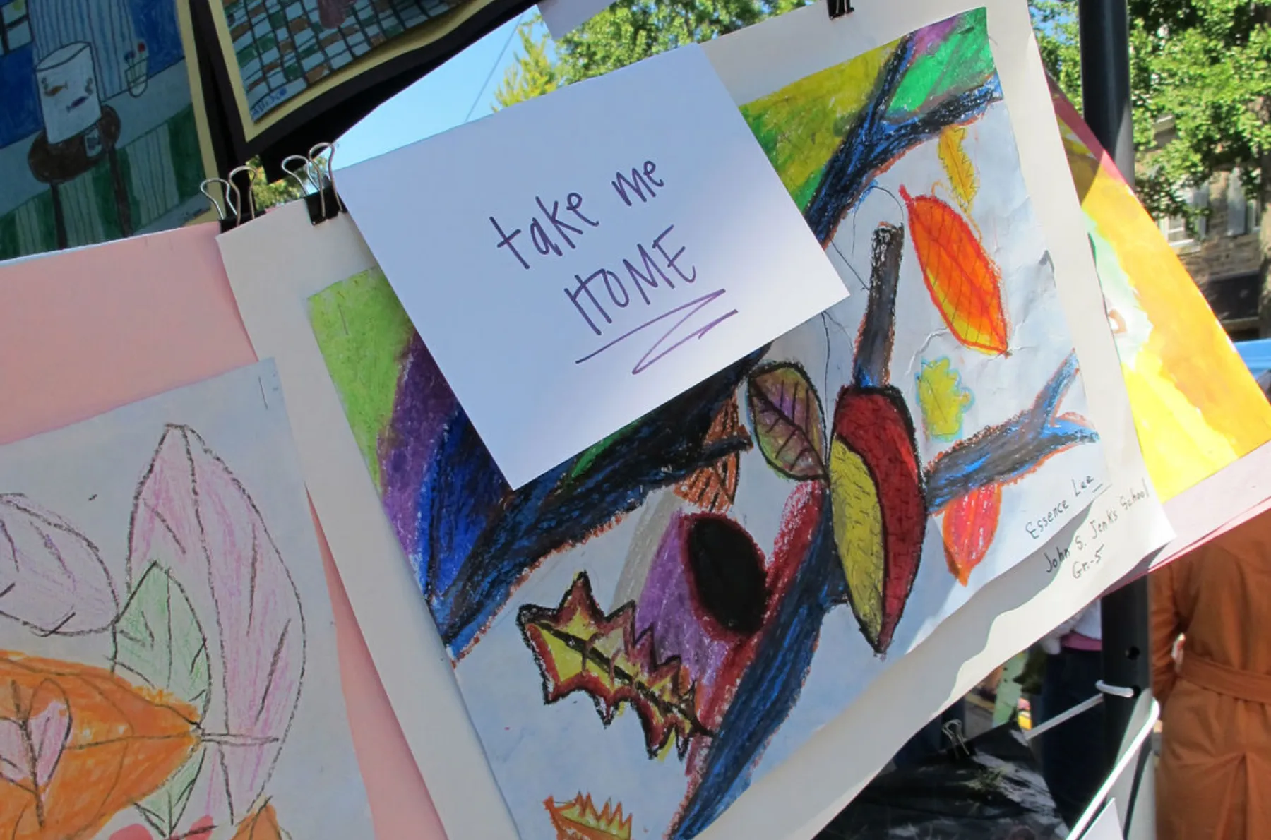 A group of children's artwork hanging on a clothes line