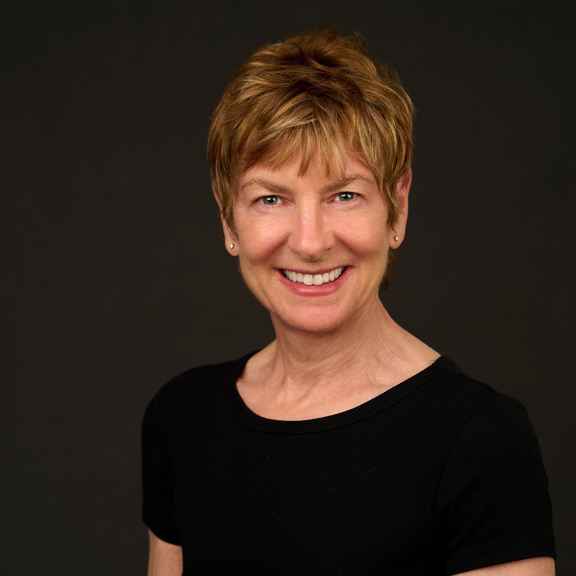A woman with short hair smiling at the camera
