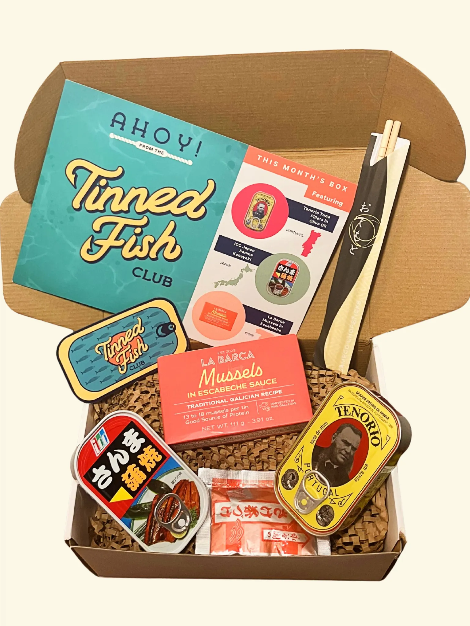 Tinned Fish Club June box with three curated tins, paired snacks, and recipe cards