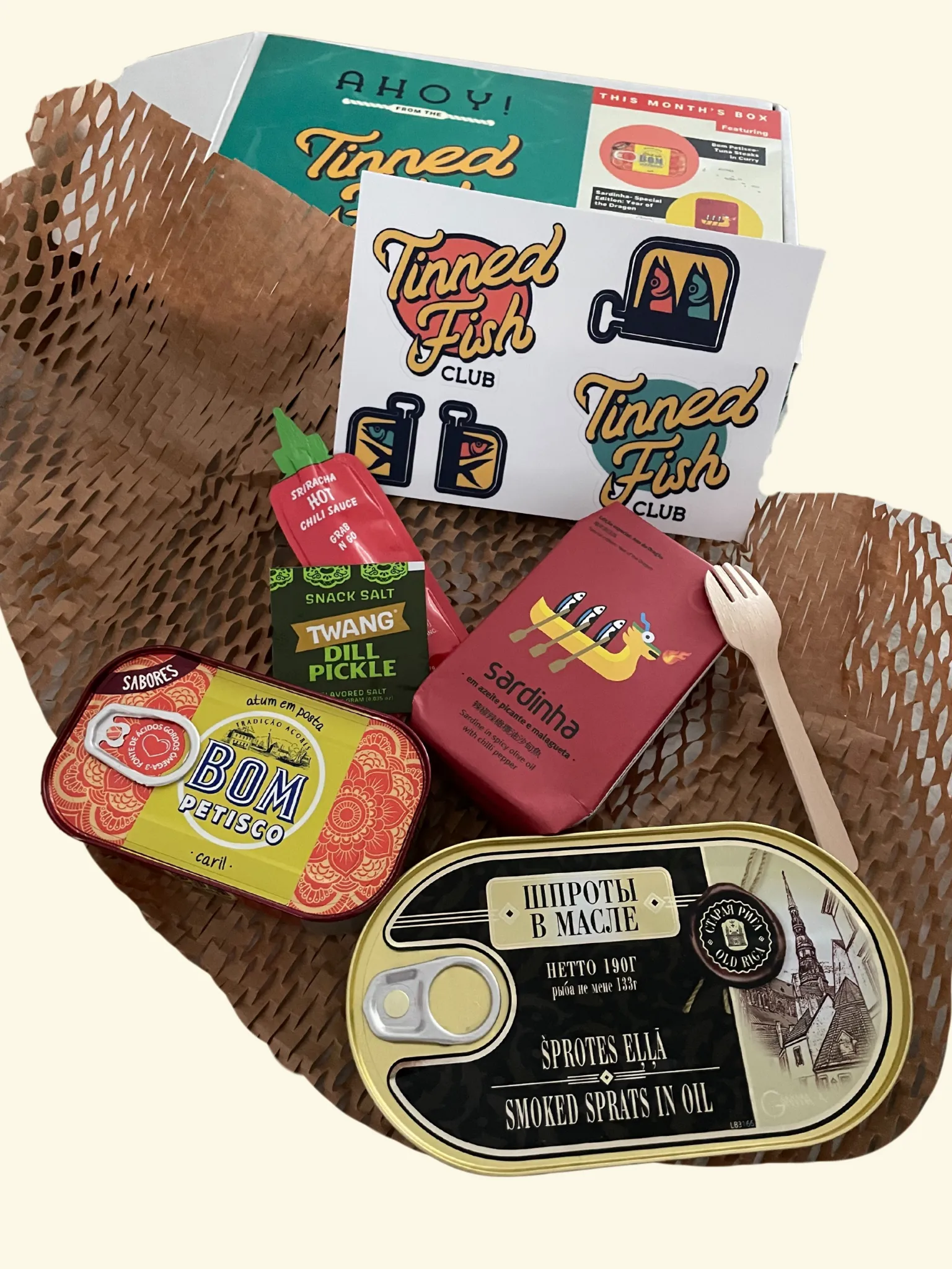 Tinned Fish Club April box with three artisanal tins and pairing condiments
