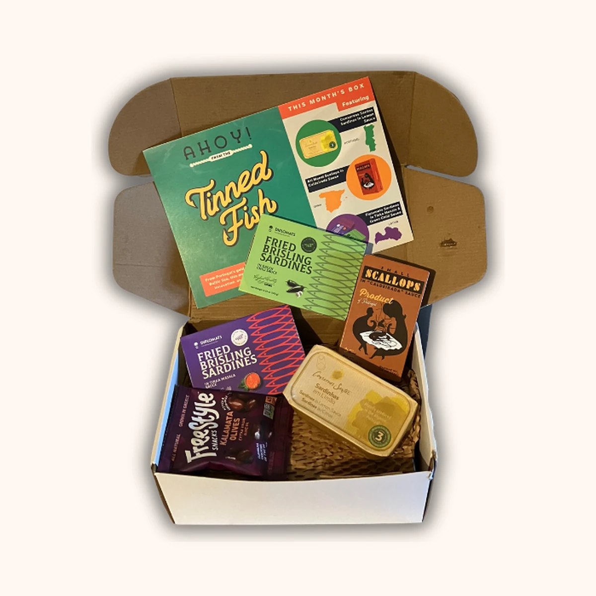 Tinned Fish Club April box with three artisanal tins and pairing condiments