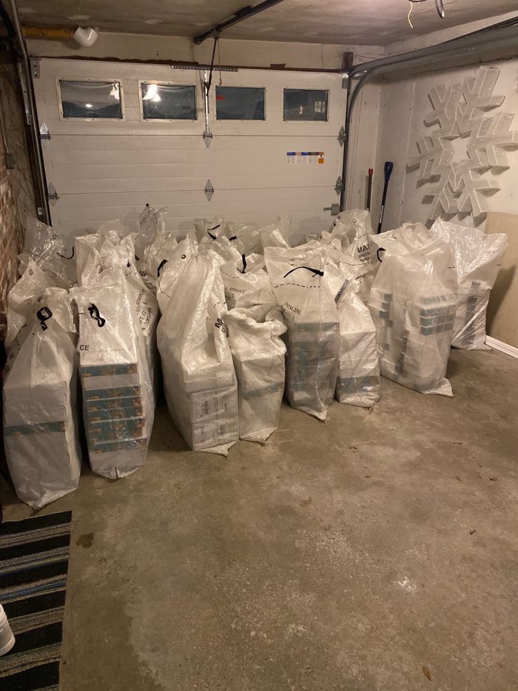 Full USPS mail sacks lined up in a garage