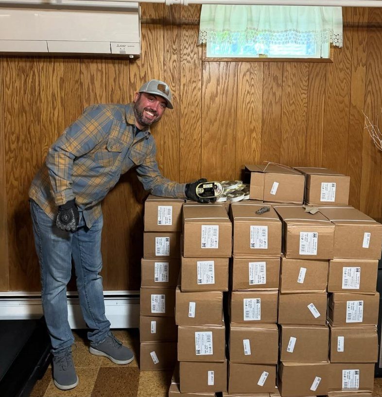 Nick beside a stack of shipping cartons