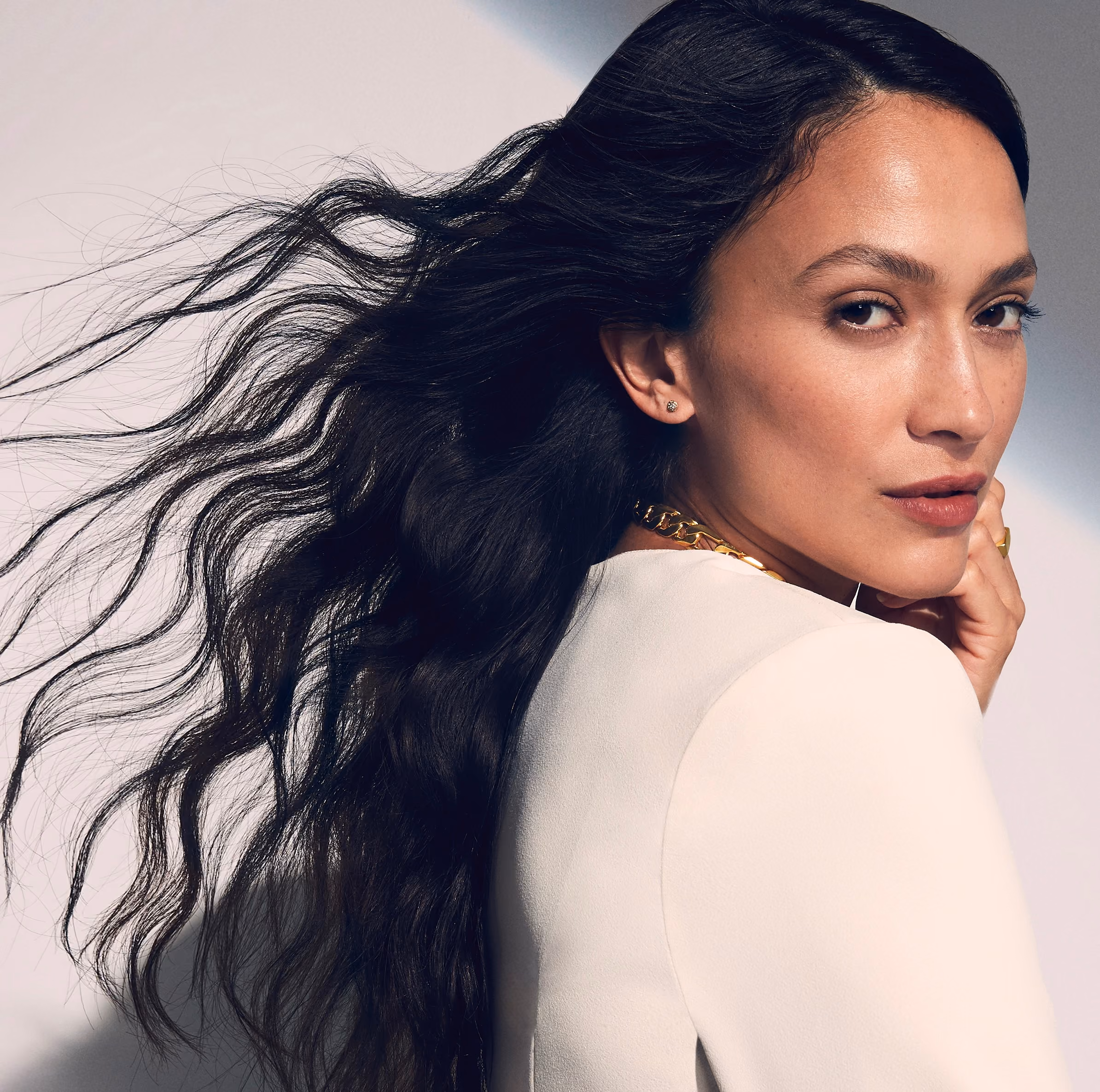 Woman with dark flowing hair, beautiful skin and youthful face. 