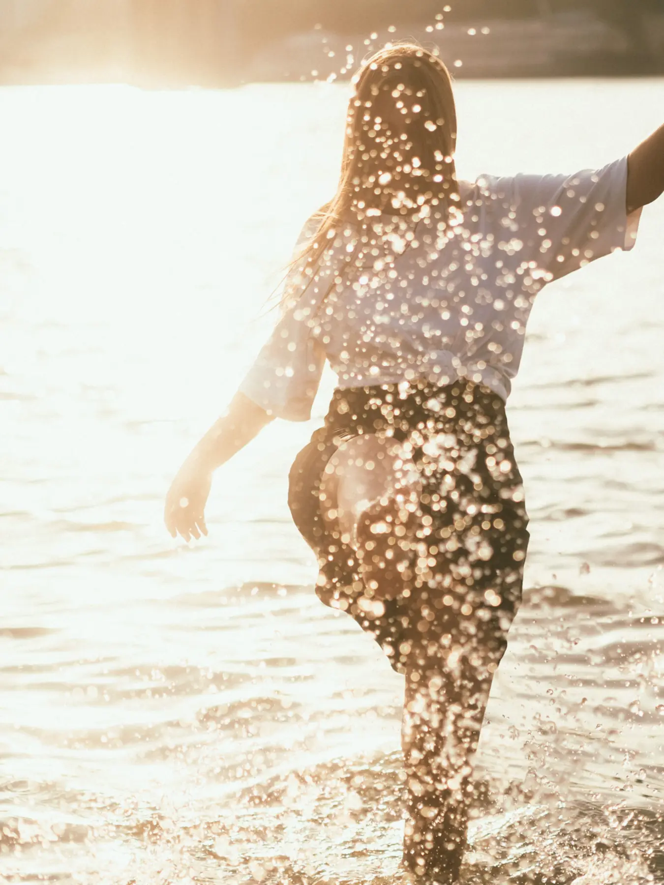 Woman sitting peacefully beside the water, representing balance and well-being during menopause care