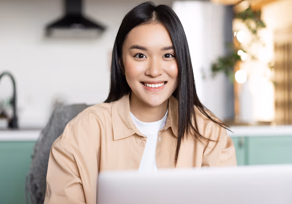 freelance-asian-girl-sitting-home-working-with-laptop-smiling-camera-young-woman-using-com image