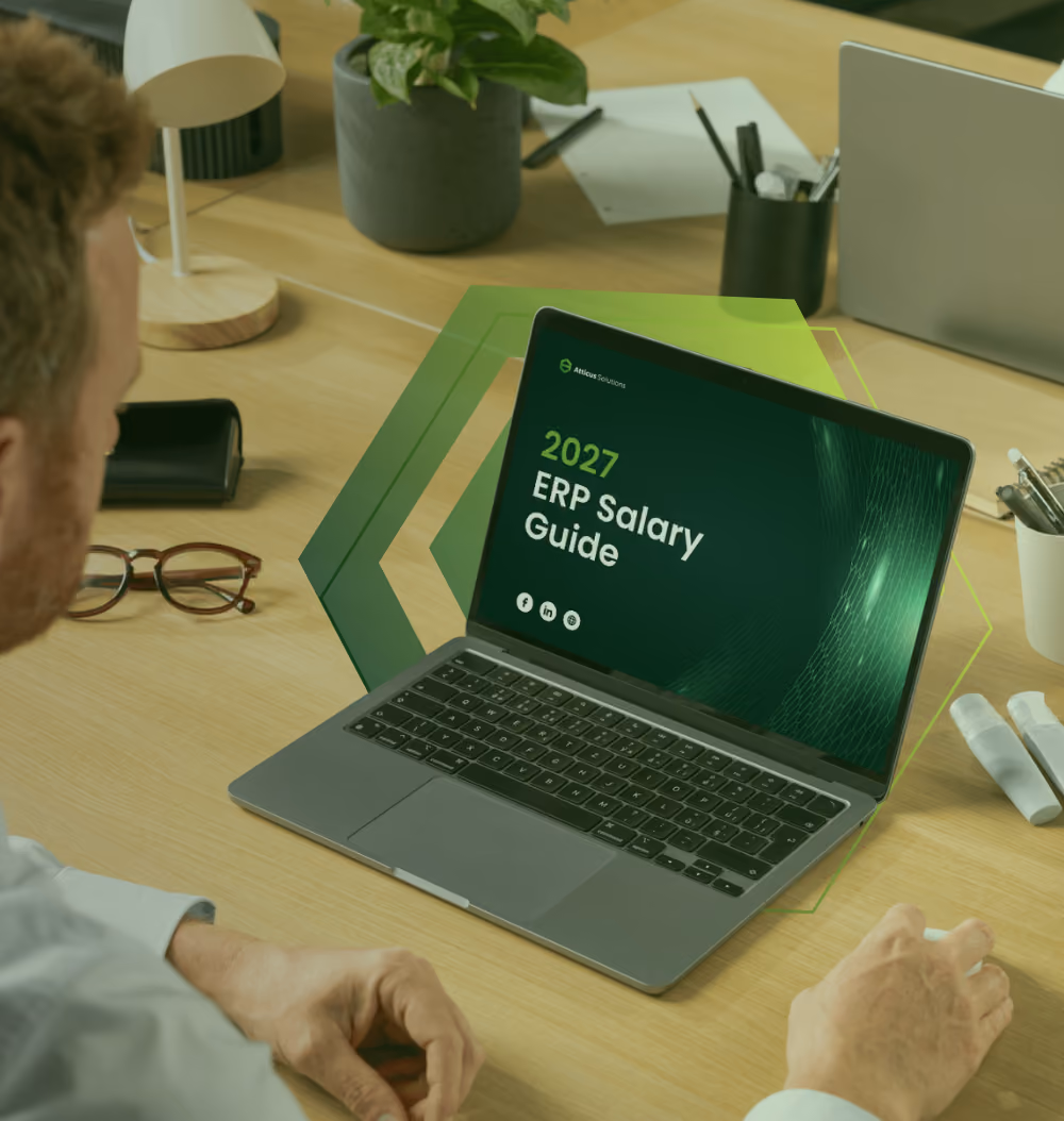 A close-up of a person's hands using a tablet to view the 2026 ERP Salary Guide by Atticus Solutions