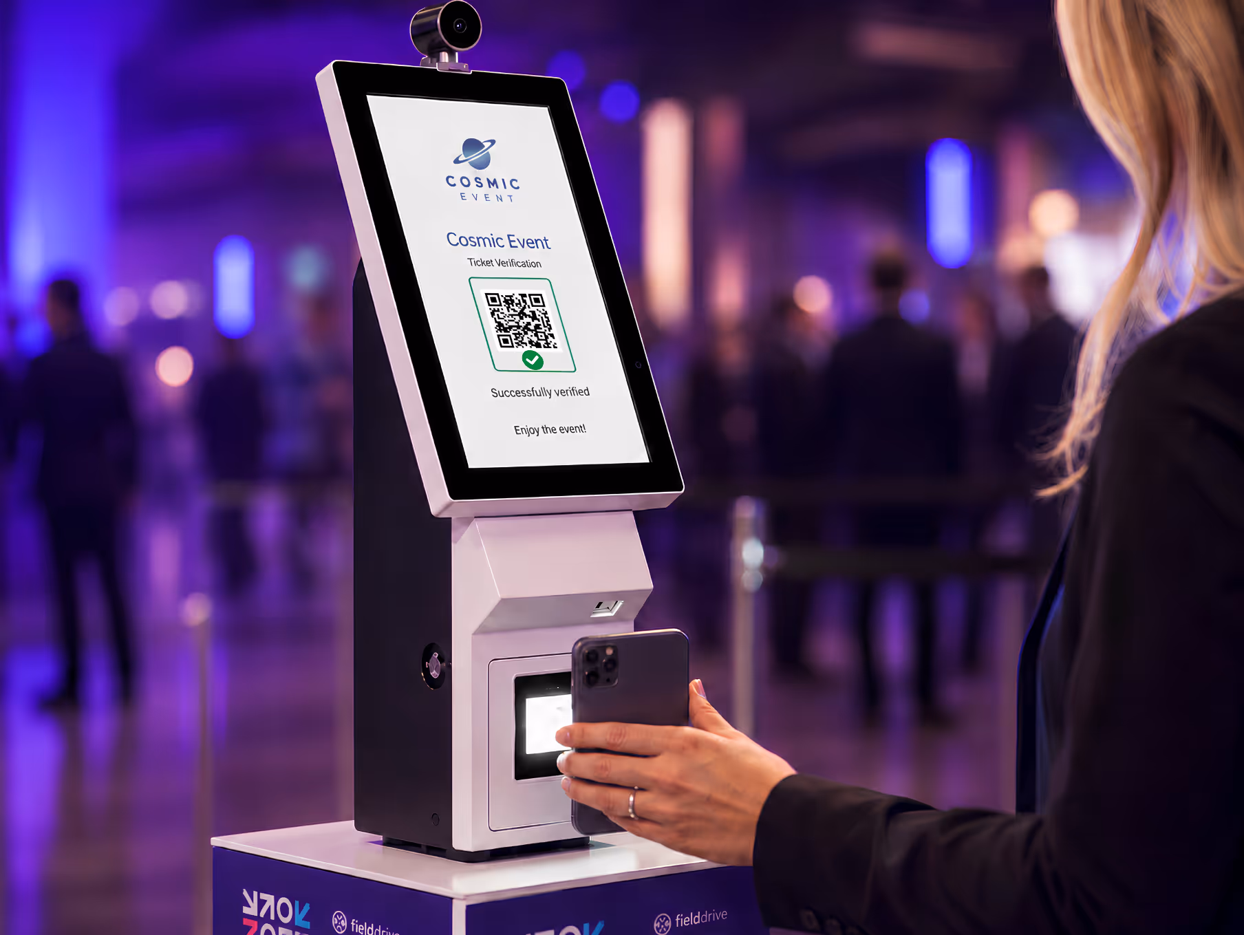 Person scanning a QR code on a phone at a ticket verification kiosk for a Cosmic Event.