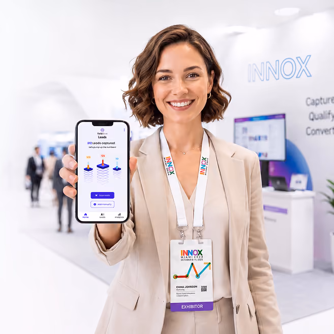 Smiling woman in beige suit at trade show showing smartphone screen with leads captured app.