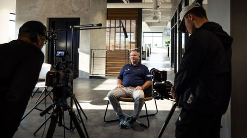 Man sitting before cameras