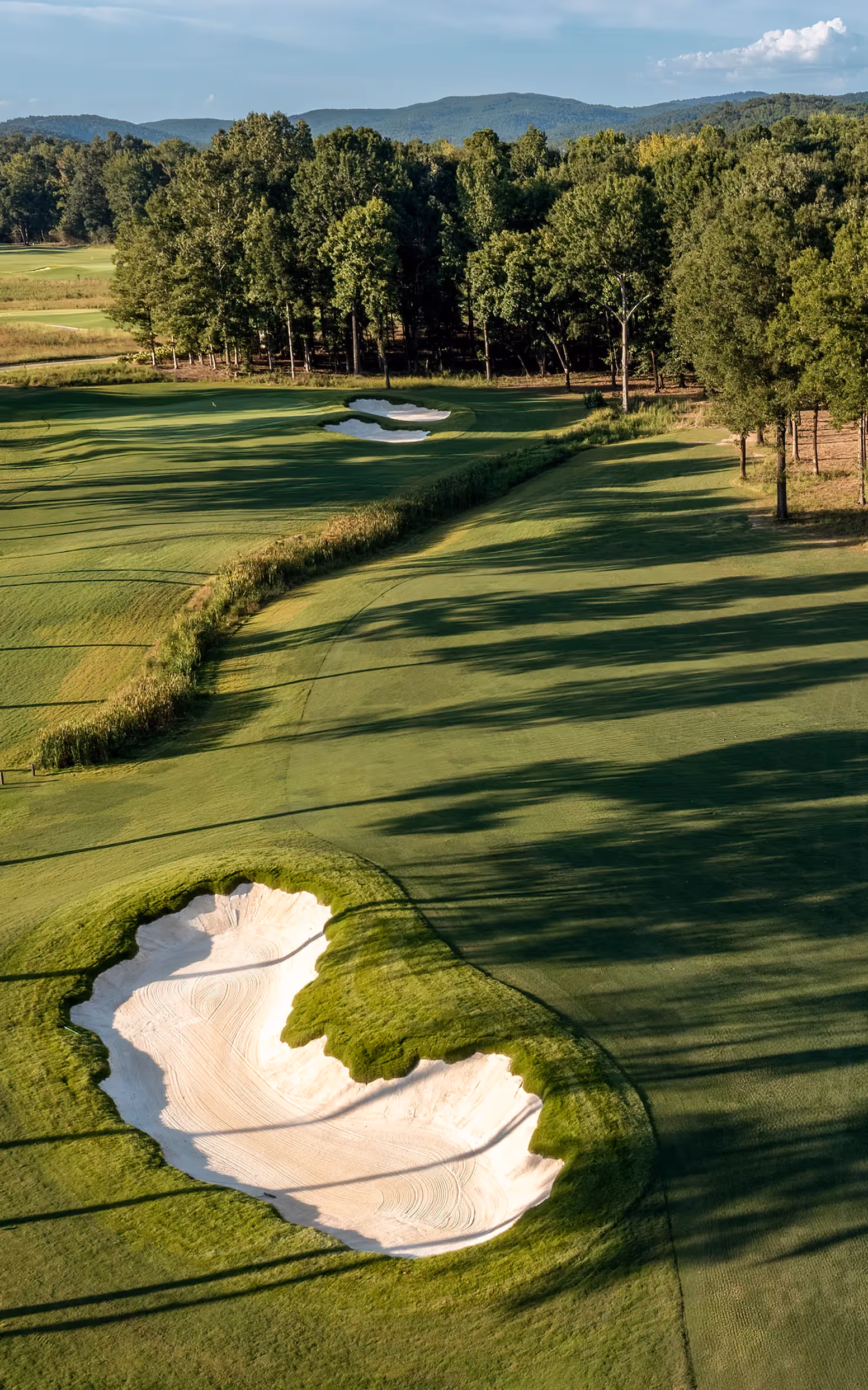 Sky view of open putting green and flag pole with yellow flag
