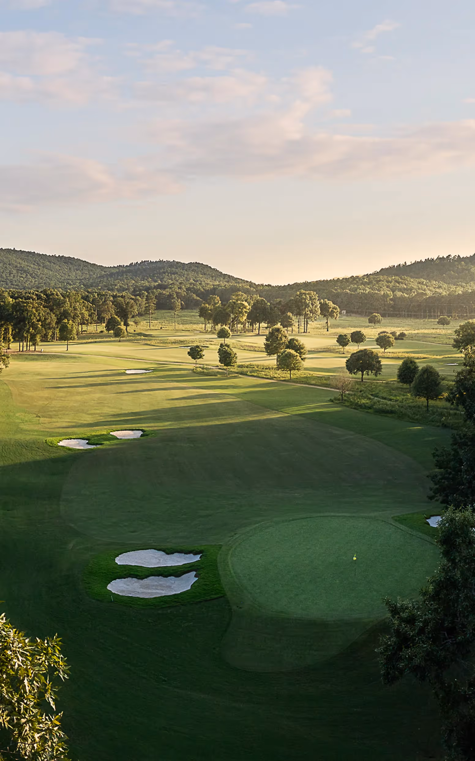 Sky view of open putting green and flag pole with yellow flag