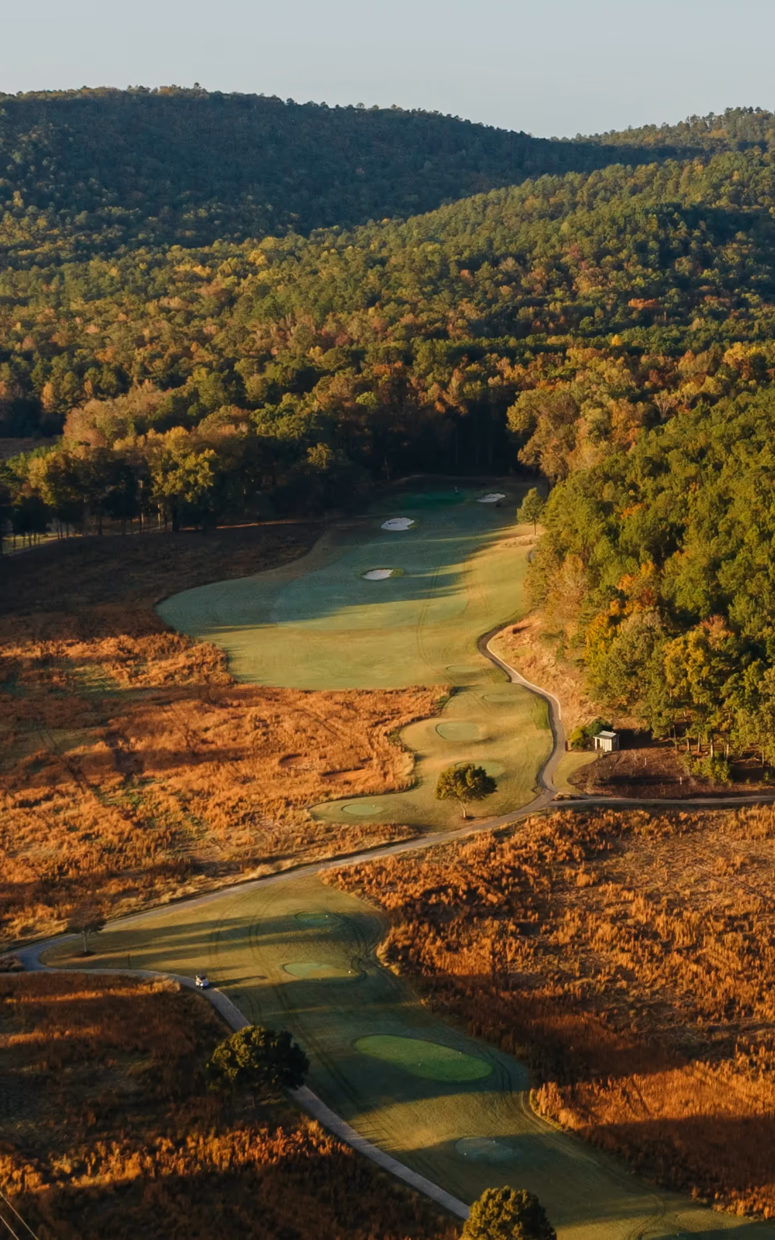 Sky view of open putting green and flag pole with yellow flag