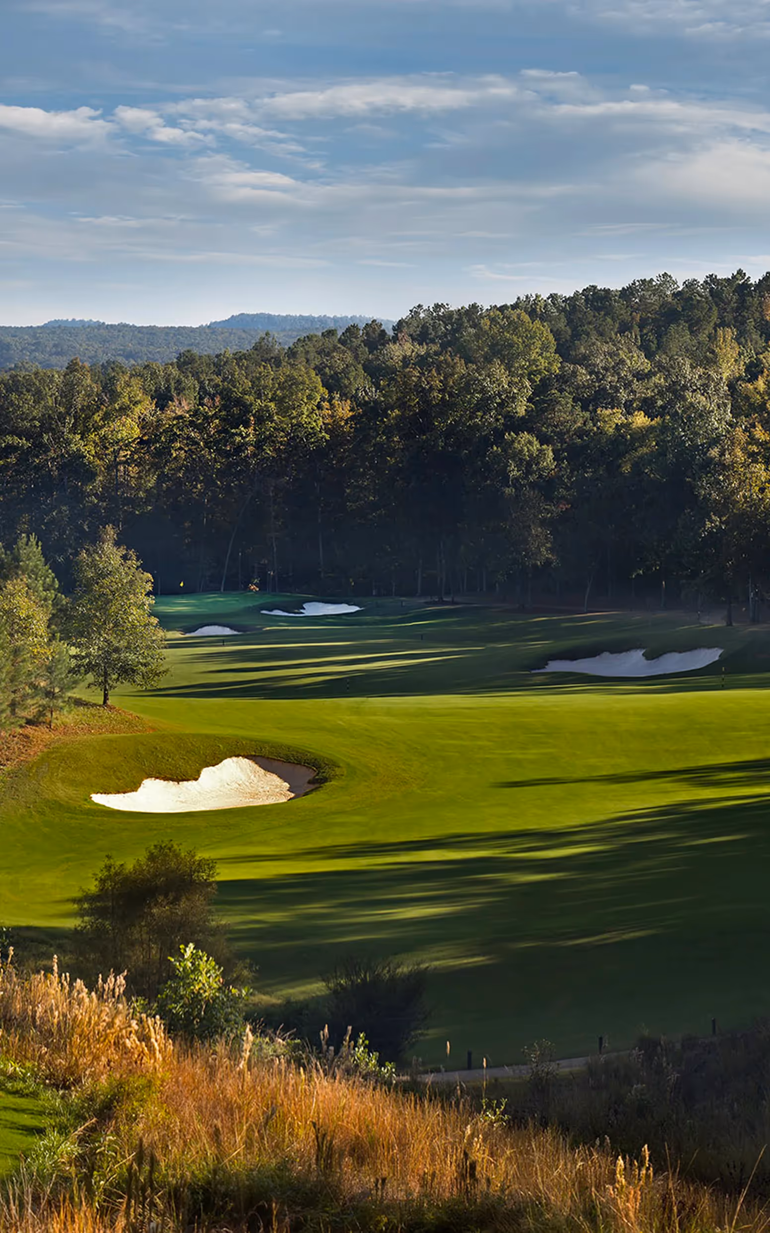 Sky view of open putting green and flag pole with yellow flag