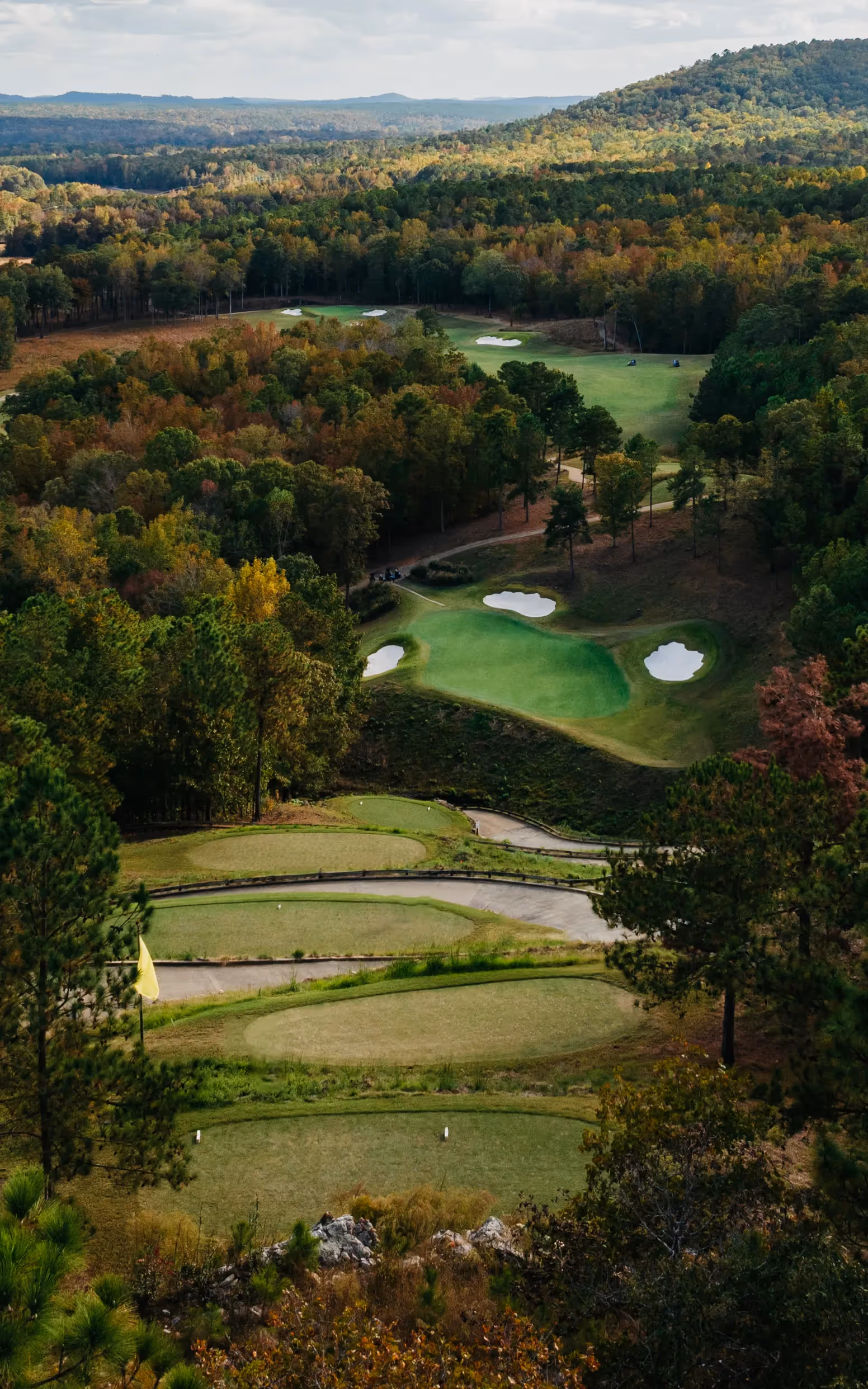 Sky view of open putting green and flag pole with yellow flag