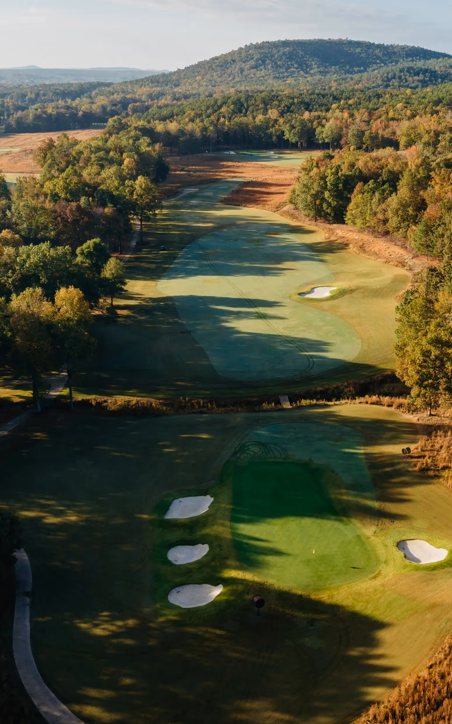 Sky view of open putting green and flag pole with yellow flag