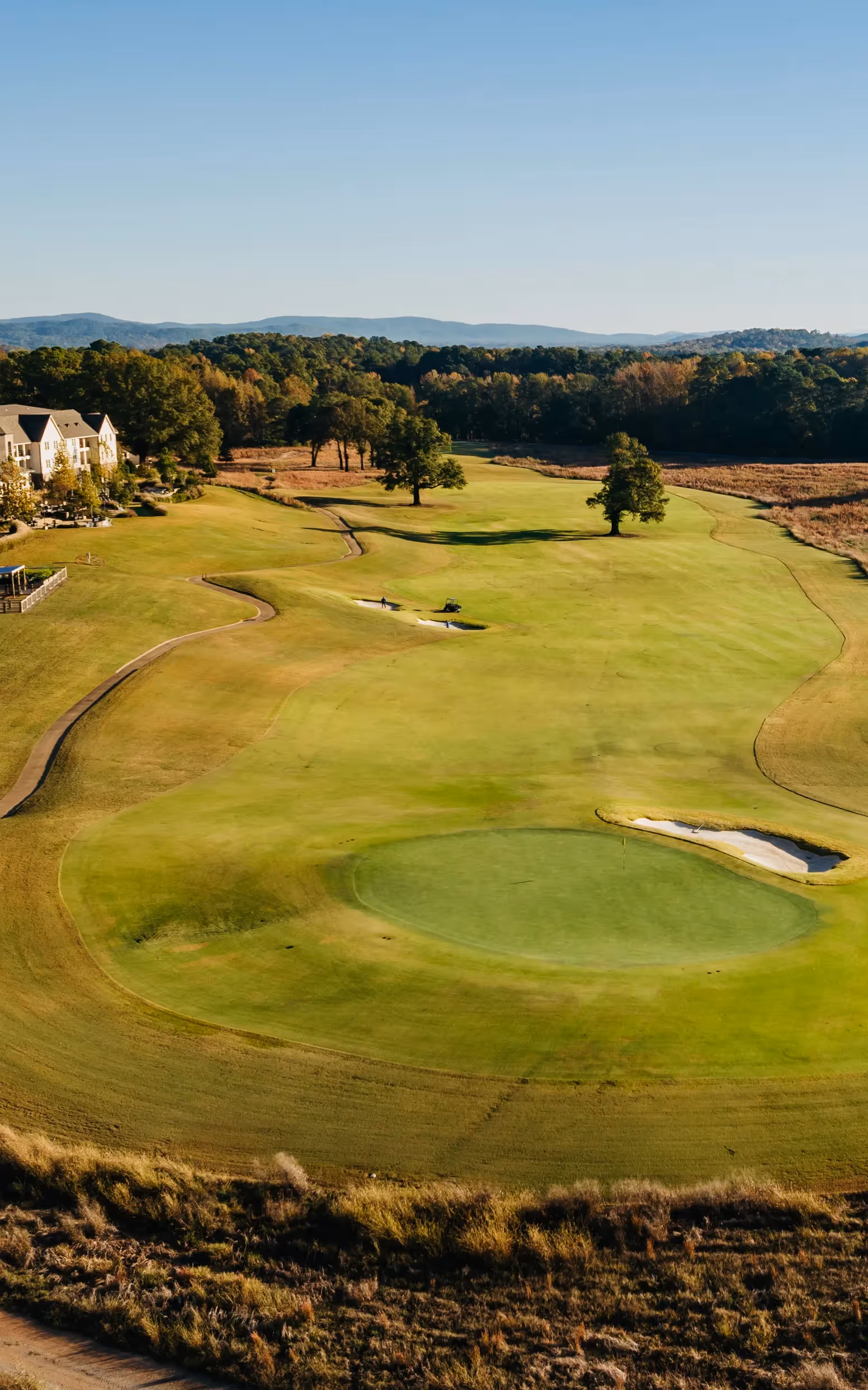 Sky view of open putting green and flag pole with yellow flag