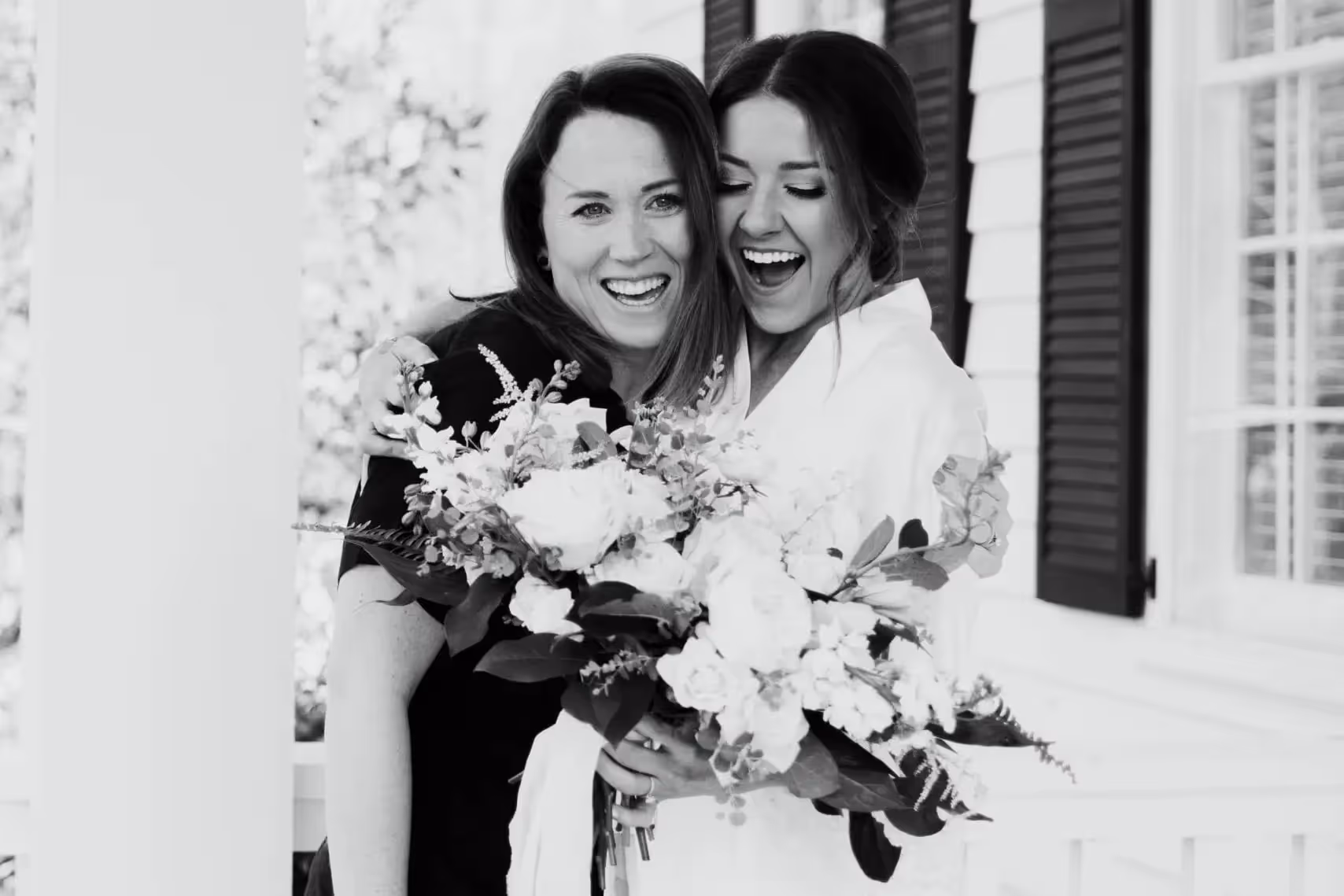 Candid picture of bride and wedding planner. Bride is holding the bouquet she will walk down the aisle with.