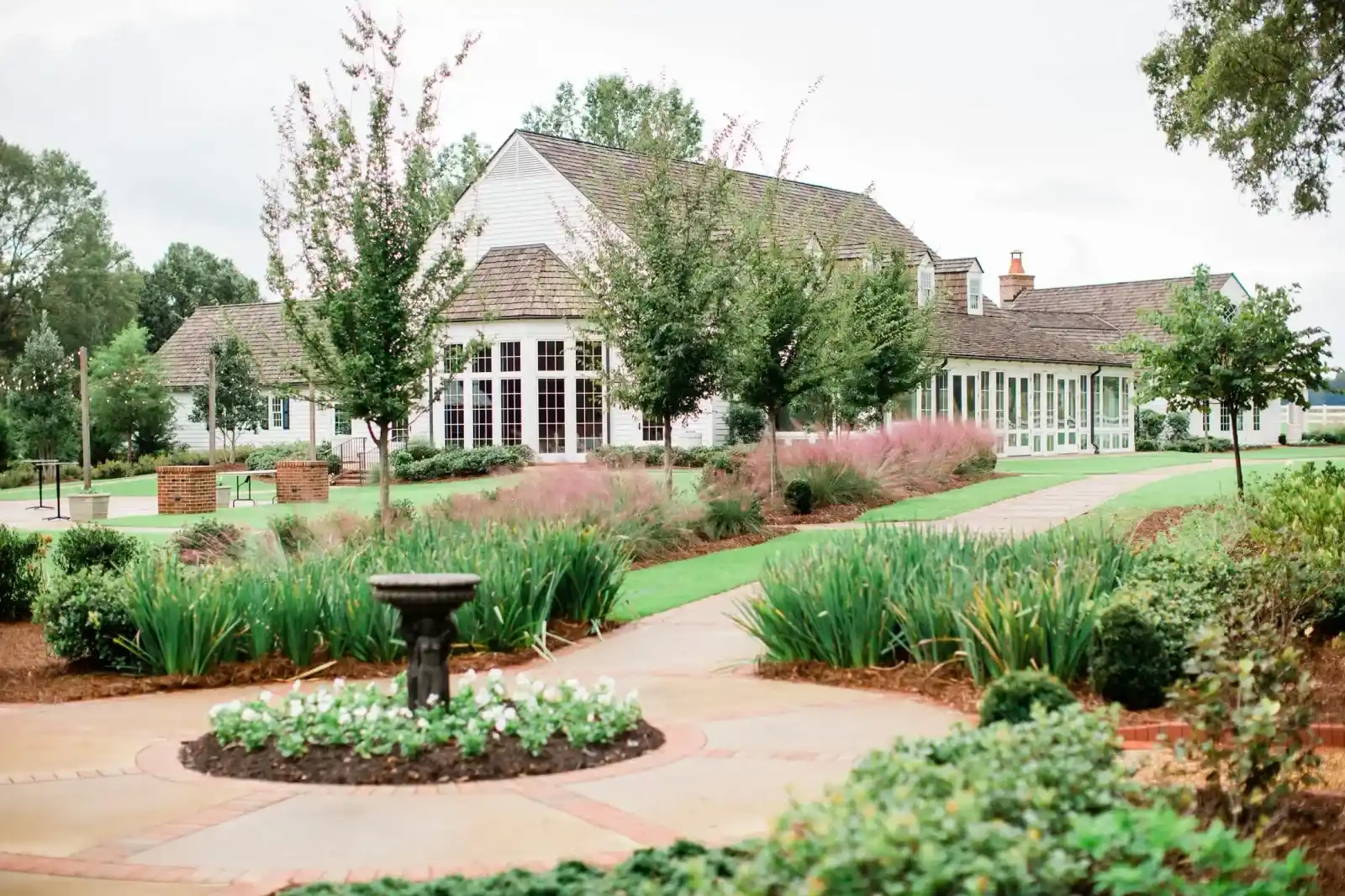 Wedding venue surrounded by inactive fountain, trees, and grass