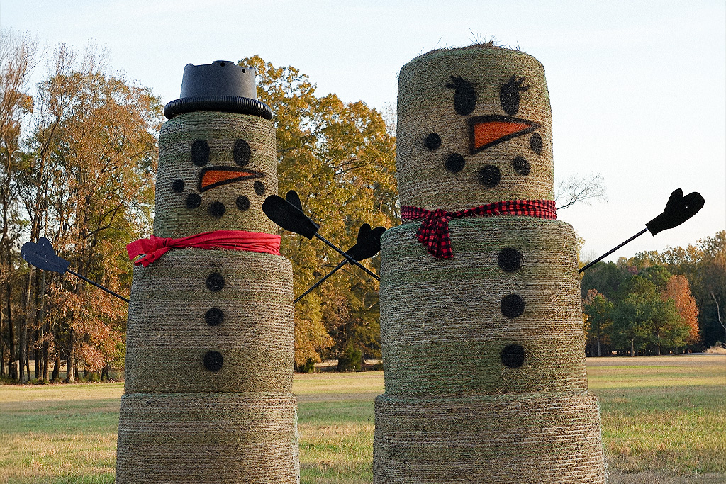 Haybale snowpeople couple in a field.
