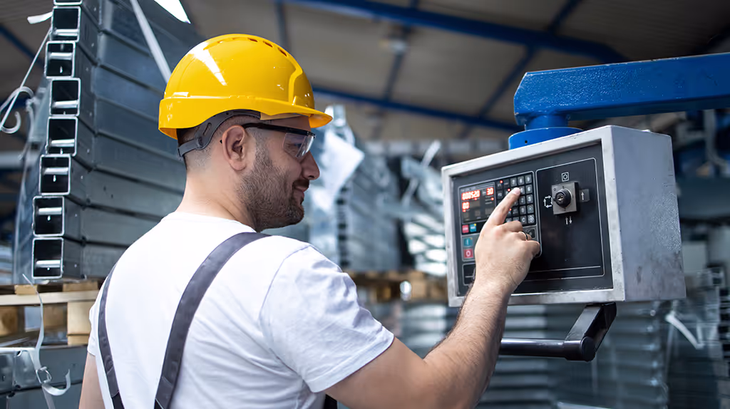 Operador trabalhando com máquina equipada com barreiras e sensores de segurança conforme NR 12