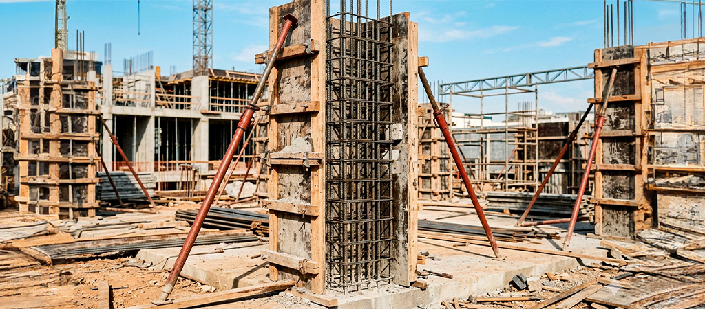  Armadura de pilar com estribos posicionados dentro de fôrma em canteiro de obras de concreto armado 