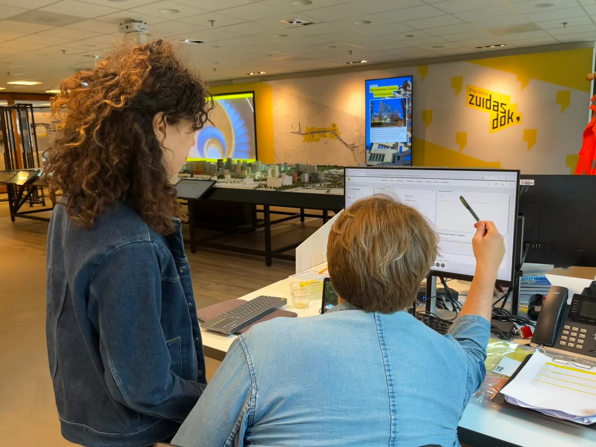 Een man en een vrouw die aan het werk zijn en samen naar een computerscherm kijken