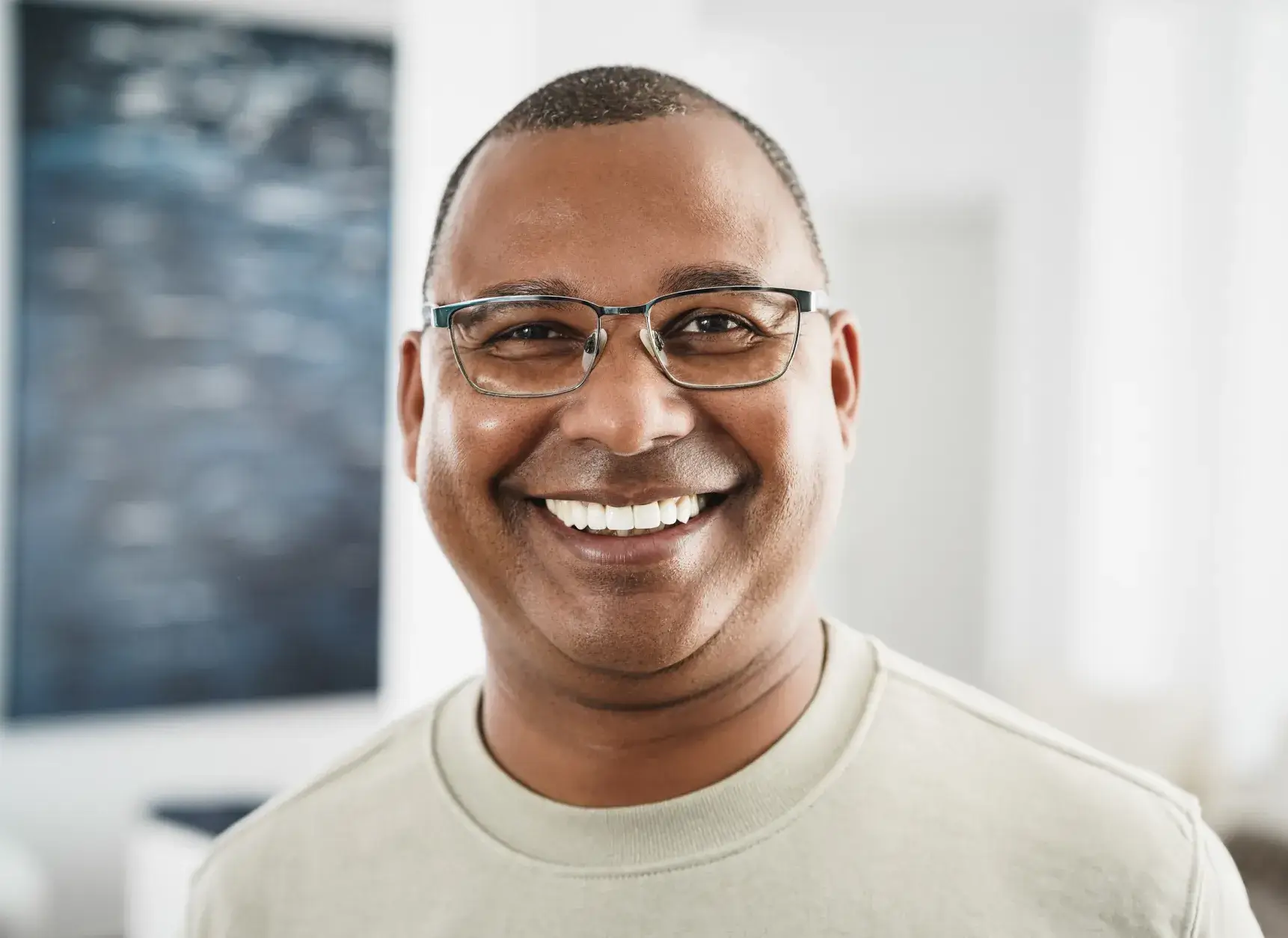 a man with glasses smiling at the camera