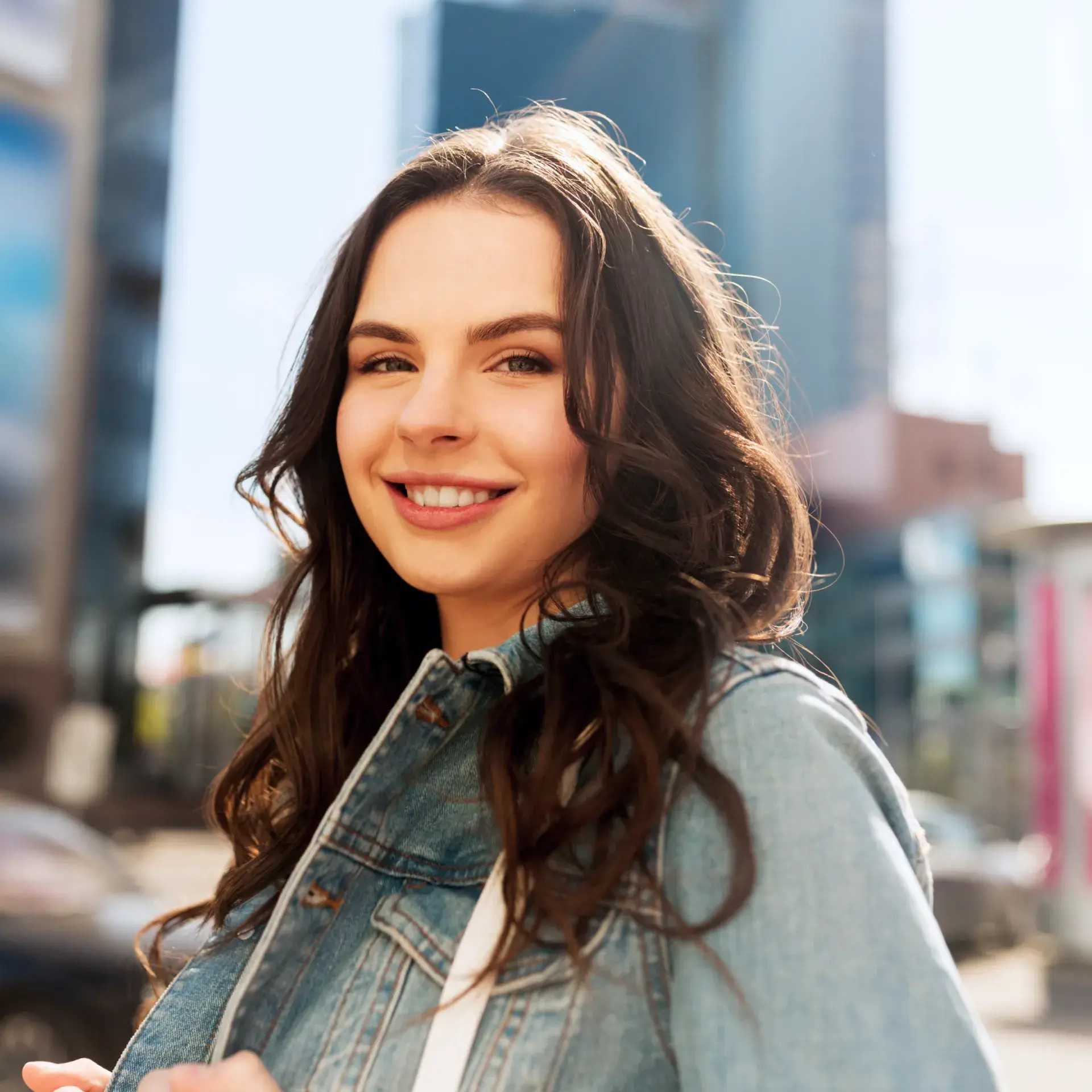 a woman in a jean jacket smiles at the camera