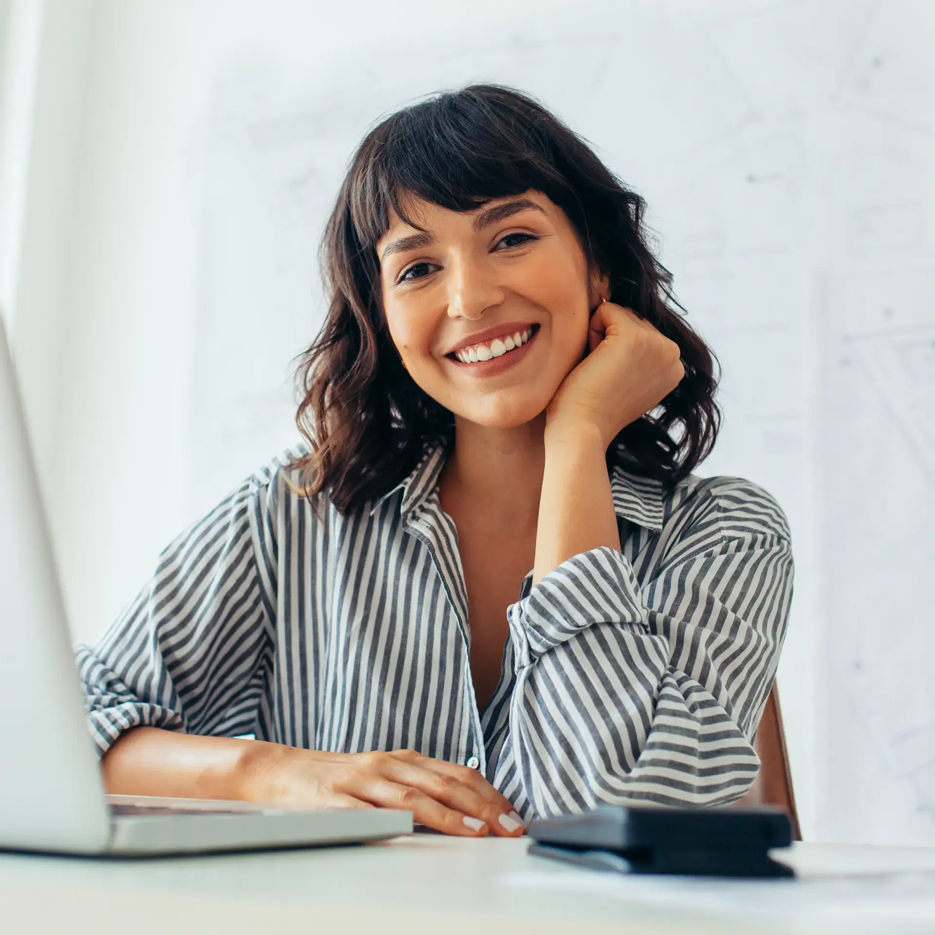 a woman sitting in front of a laptop computer