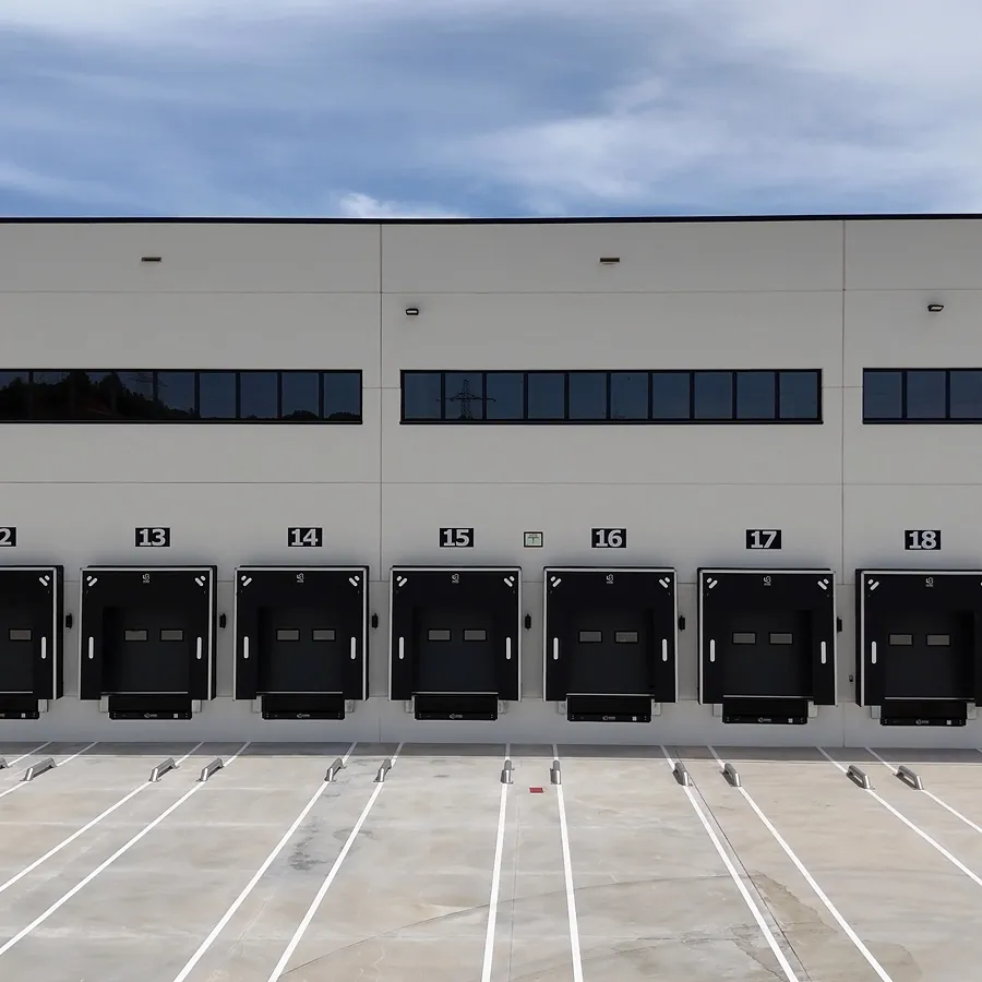 Industrial warehouse loading docks under clear blue sky.