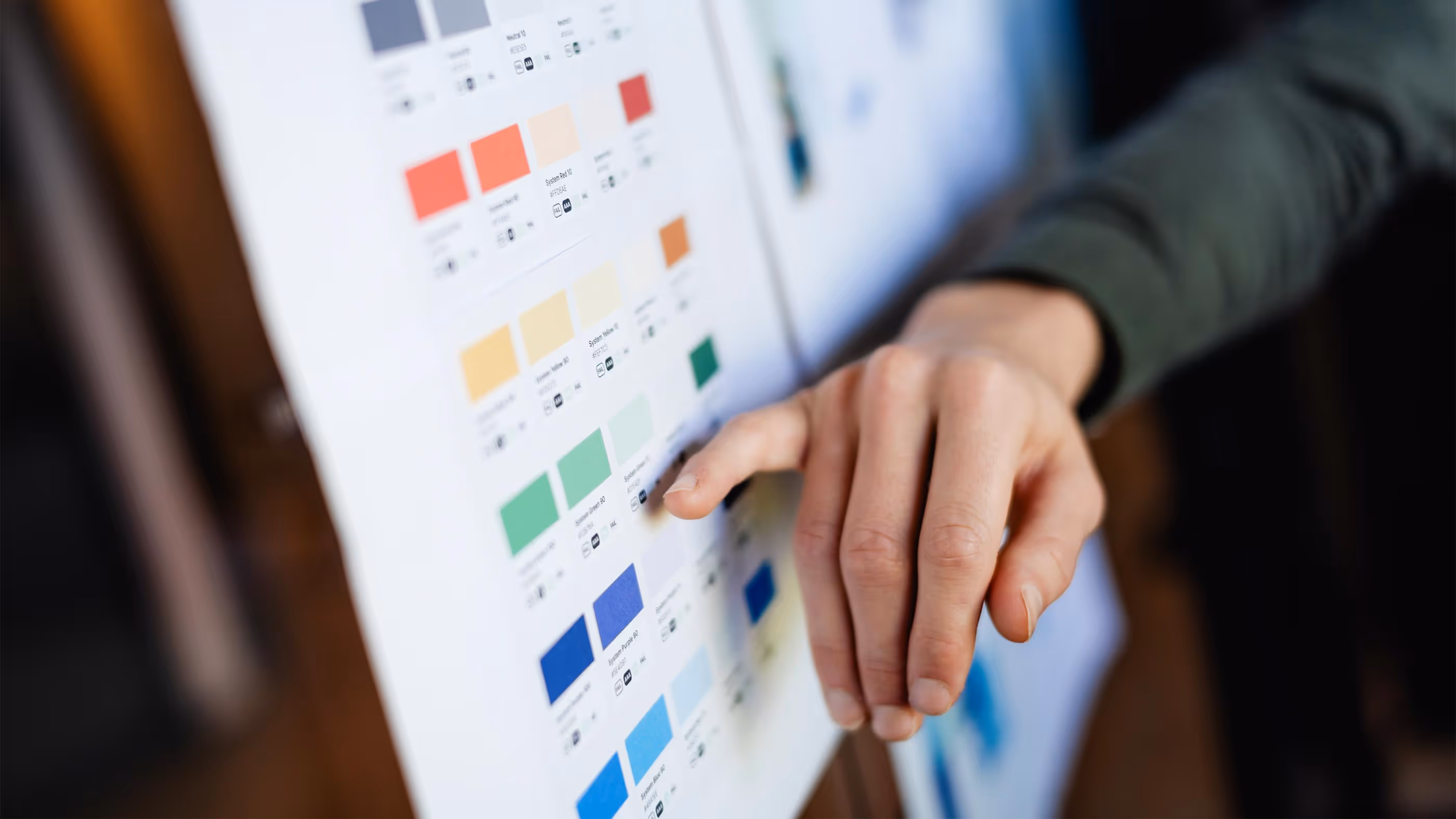 En hånd peker på en printet fargepalett