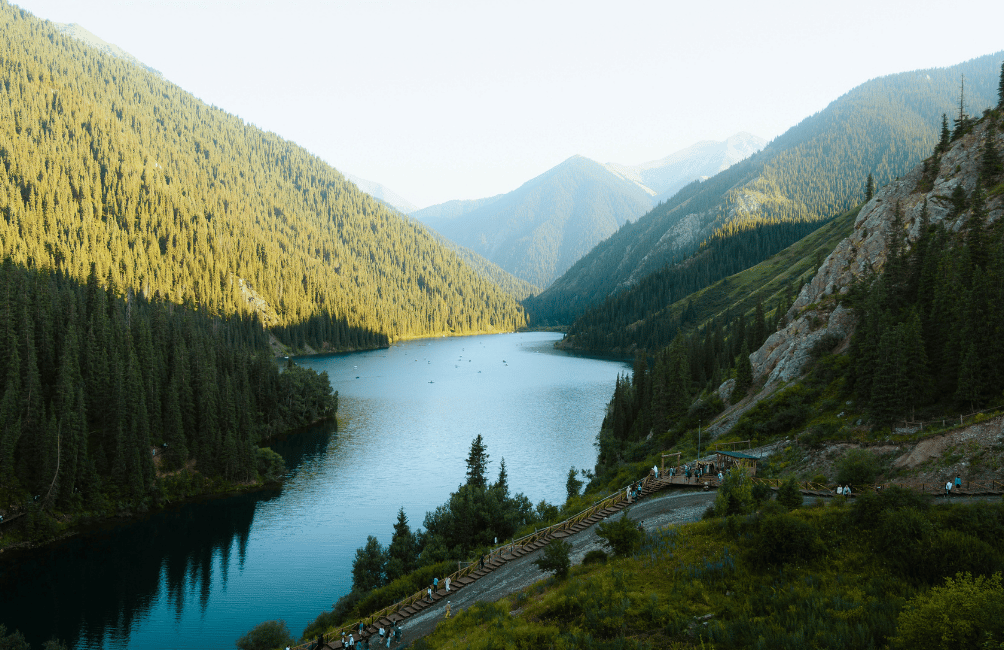 Lac Kolsay inférieur entouré de sapins et de sommets enneigés, Kazakhstan