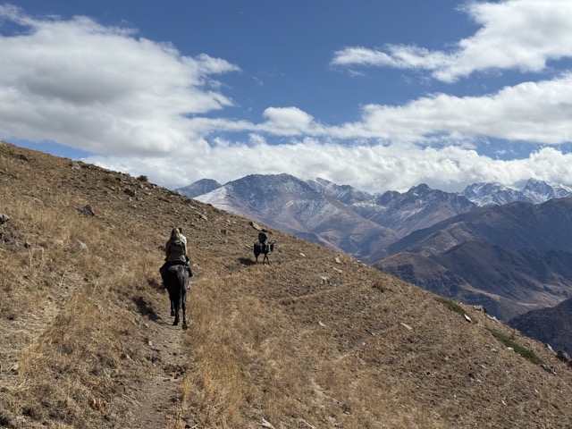 Two riders on a ridge trail in the Tian Shan mountains