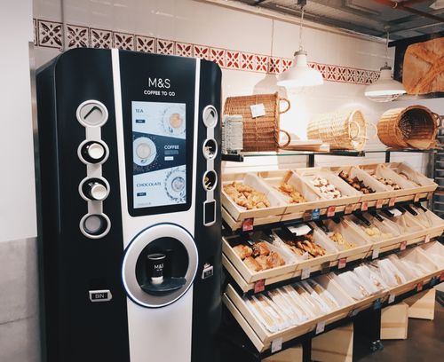 A vending machine in front of a display of pastries