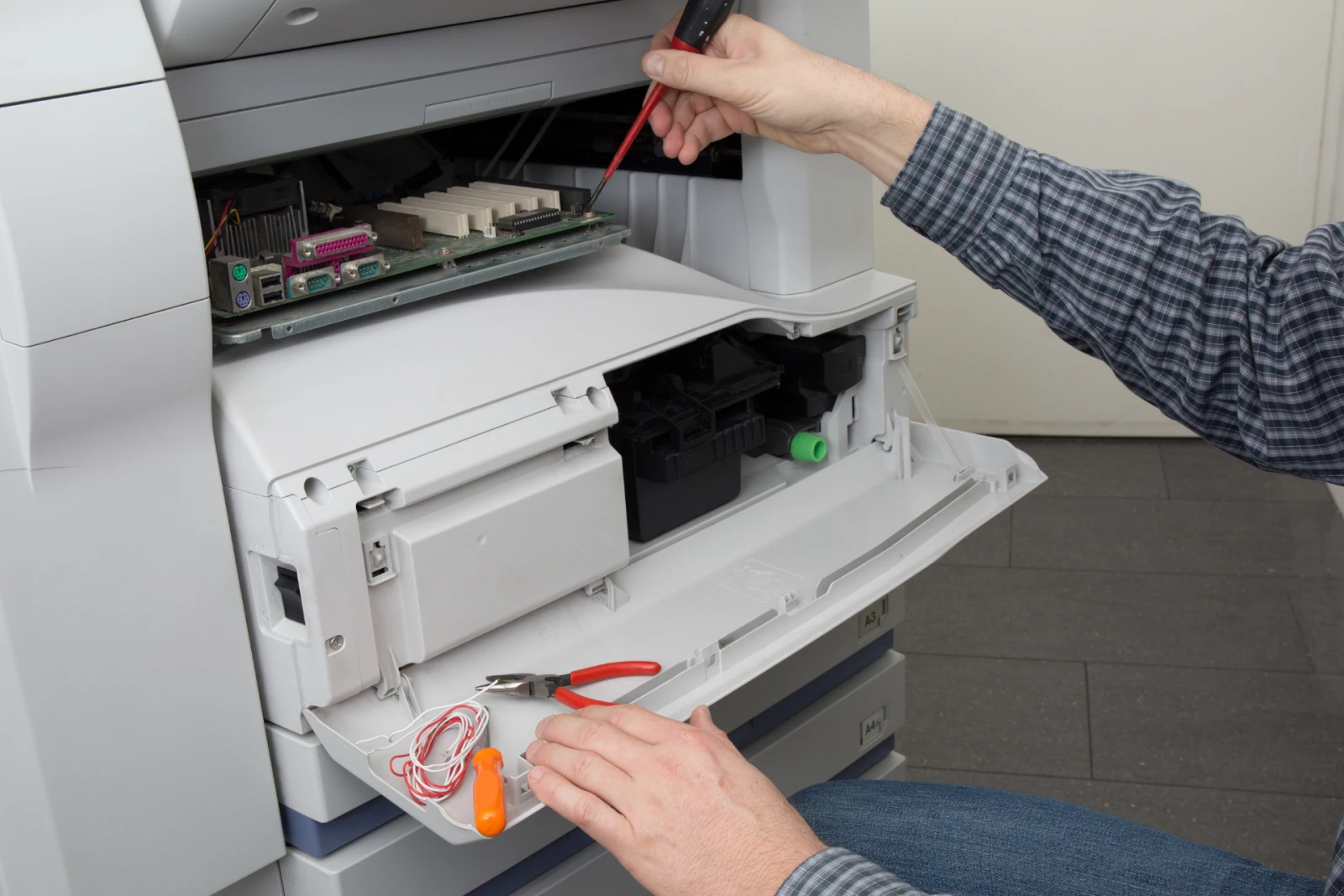 technician from a managed print solutions company repairing a printer