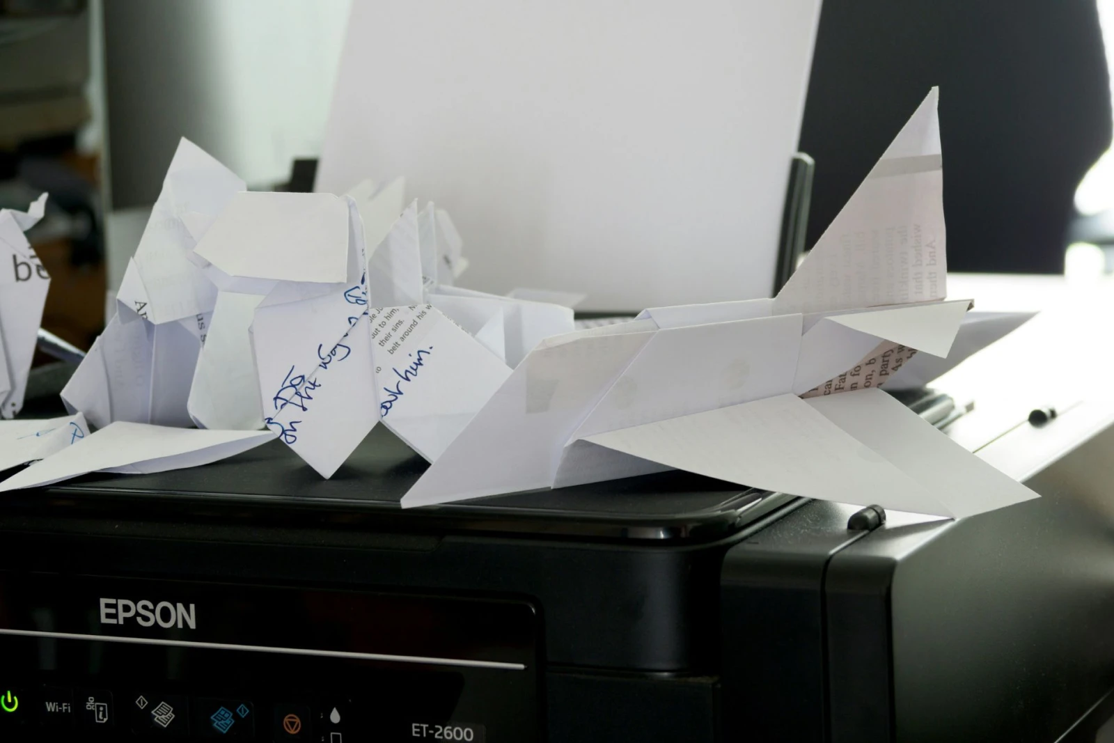 A bunch of paper waste sitting on top of a printer