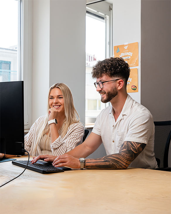 Ein Mann und eine Frau arbeiten zusammen im Büro am Computer